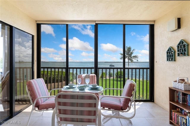 400 E Lenell Unit 110, Fort Myers Beach, FL 33931 - sunroom / solarium featuring expansive windows, a water view, a textured wall, plenty of natural light, and tile patterned floors
