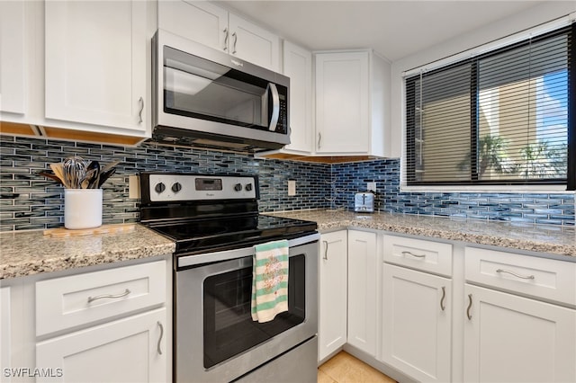 400 E Lenell Unit 110, Fort Myers Beach, FL 33931 - kitchen with stainless steel appliances, decorative backsplash, white cabinets, and light stone counters