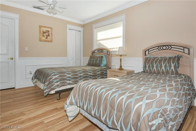 770 93rd Ave N, Naples, FL 34108 - bedroom with wood finished floors, a wainscoted wall, a closet, crown molding, and ceiling fan