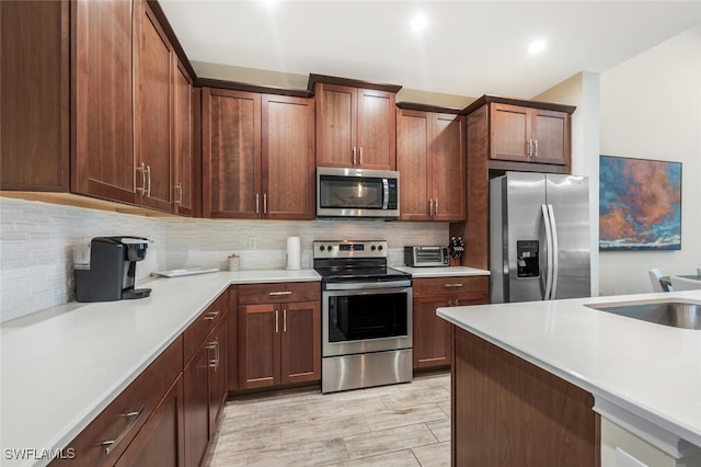4720 Arboretum Cir Unit 102, Naples, FL 34112 - kitchen with appliances with stainless steel finishes, decorative backsplash, and light countertops