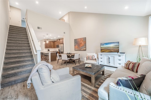 4720 Arboretum Cir Unit 102, Naples, FL 34112 - living room with stairs, light wood-style floors, recessed lighting, and a towering ceiling