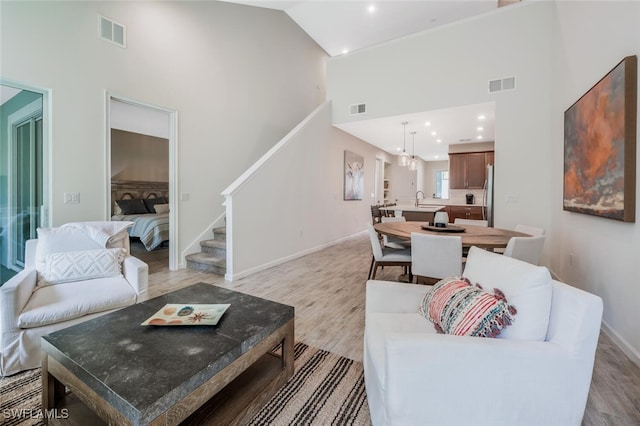 4720 Arboretum Cir Unit 102, Naples, FL 34112 - living area featuring high vaulted ceiling, stairs, light wood-style floors, and recessed lighting