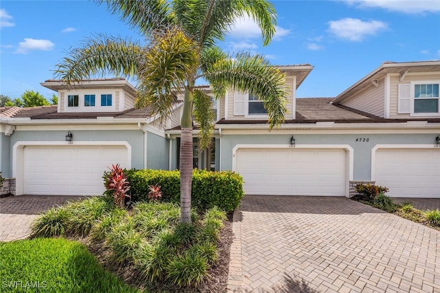 4720 Arboretum Cir Unit 102, Naples, FL 34112 - traditional-style home with decorative driveway, stucco siding, and a garage