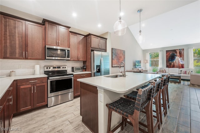 4720 Arboretum Cir Unit 102, Naples, FL 34112 - kitchen featuring stainless steel appliances, open floor plan, a breakfast bar, tasteful backsplash, and light countertops