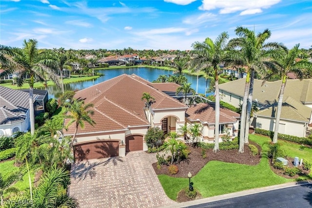 14581 Headwater Bay Ln, Fort Myers, FL 33908 - view of front of home with an attached garage, a water view, a residential view, a tiled roof, and driveway
