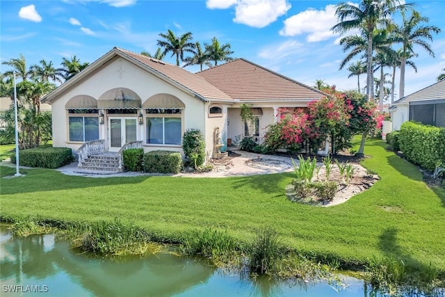14581 Headwater Bay Ln, Fort Myers, FL 33908 - view of front facade with a front yard, french doors, stucco siding, and a tiled roof