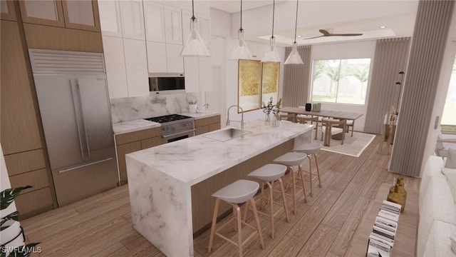 1021 Gaucho Ter, North Port, FL 34286 - kitchen with modern cabinets, high quality appliances, a breakfast bar area, light wood-style flooring, and a center island with sink