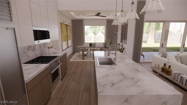 1021 Gaucho Ter, North Port, FL 34286 - kitchen with white microwave, modern cabinets, dark wood-style flooring, freestanding refrigerator, and a tray ceiling