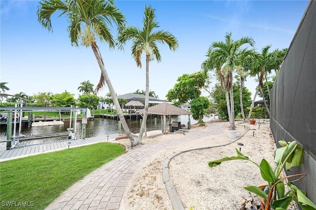 1138 Lucerne Ave, Cape Coral, FL 33904 - dock with boat lift, a water view, and a lawn
