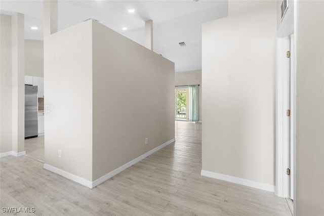 2811 44th St W, Lehigh Acres, FL 33971 - corridor featuring light wood finished floors, a high ceiling, and recessed lighting