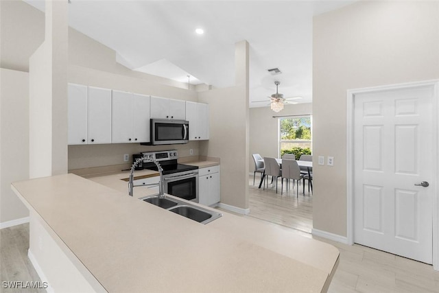 2811 44th St W, Lehigh Acres, FL 33971 - kitchen with stainless steel appliances, a ceiling fan, white cabinetry, light countertops, and a peninsula