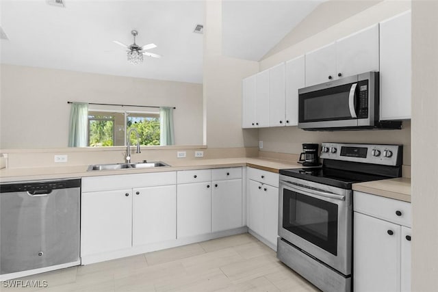 2811 44th St W, Lehigh Acres, FL 33971 - kitchen featuring appliances with stainless steel finishes, light countertops, white cabinets, vaulted ceiling, and ceiling fan