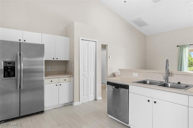 2811 44th St W, Lehigh Acres, FL 33971 - kitchen featuring appliances with stainless steel finishes, vaulted ceiling, light countertops, and white cabinets