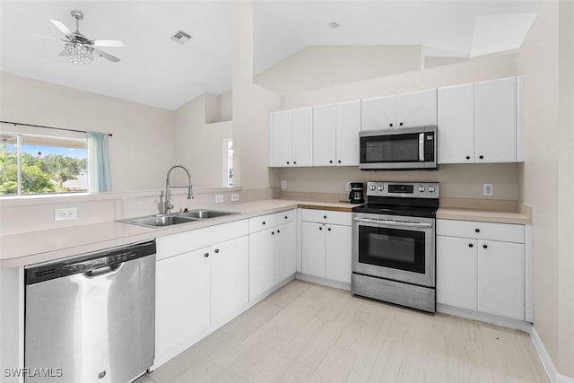 2811 44th St W, Lehigh Acres, FL 33971 - kitchen featuring stainless steel appliances, vaulted ceiling, light countertops, white cabinetry, and ceiling fan