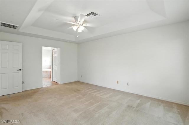 4322 NW 32nd Ter, Cape Coral, FL 33993 - unfurnished bedroom with a tray ceiling, light colored carpet, ensuite bathroom, and ceiling fan