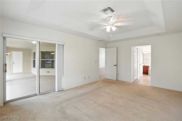 4322 NW 32nd Ter, Cape Coral, FL 33993 - unfurnished bedroom featuring a raised ceiling, carpet flooring, ensuite bathroom, and ceiling fan