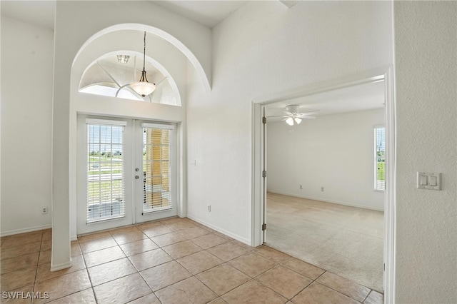 4322 NW 32nd Ter, Cape Coral, FL 33993 - entryway featuring french doors, healthy amount of natural light, light tile patterned flooring, light carpet, and a towering ceiling