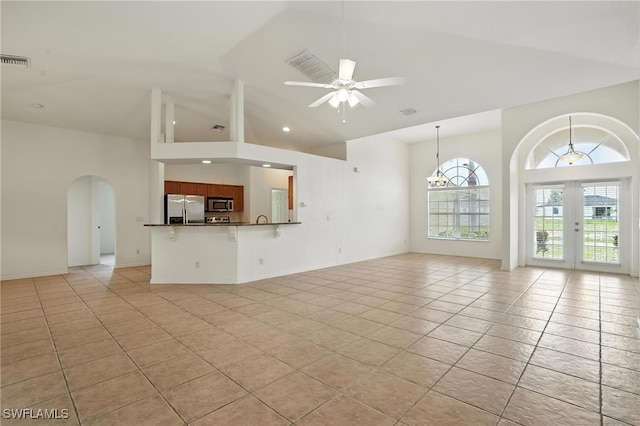 4322 NW 32nd Ter, Cape Coral, FL 33993 - unfurnished living room featuring high vaulted ceiling, arched walkways, light tile patterned flooring, ceiling fan, and french doors