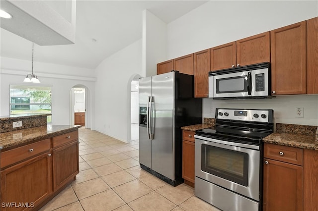 4322 NW 32nd Ter, Cape Coral, FL 33993 - kitchen featuring appliances with stainless steel finishes, vaulted ceiling, brown cabinets, arched walkways, and decorative light fixtures