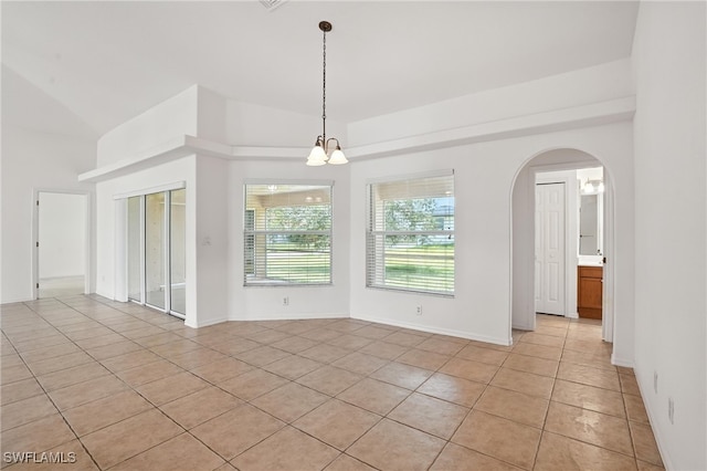 4322 NW 32nd Ter, Cape Coral, FL 33993 - empty room featuring light tile patterned floors, a chandelier, and arched walkways