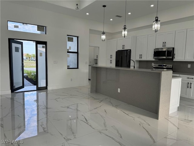 707 NE Juanita Place, Cape Coral, FL 33909 - kitchen with stainless steel appliances, a towering ceiling, light marble finish floors, a large island with sink, and recessed lighting