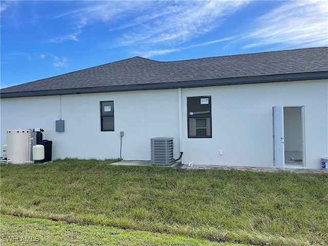 707 NE Juanita Place, Cape Coral, FL 33909 - back of house with roof with shingles, stucco siding, and a yard