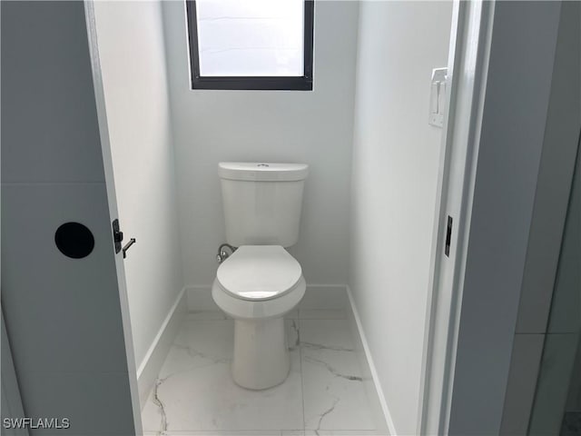707 NE Juanita Place, Cape Coral, FL 33909 - bathroom with marble look tiles and toilet