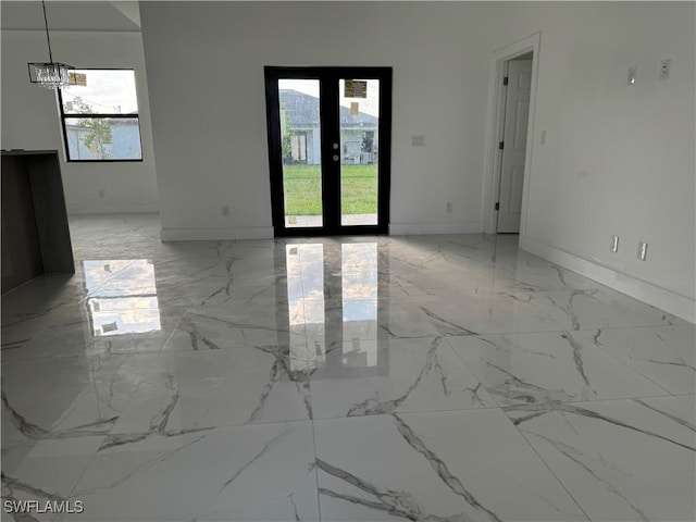 707 NE Juanita Place, Cape Coral, FL 33909 - spare room with light marble finish floors, a chandelier, and healthy amount of natural light