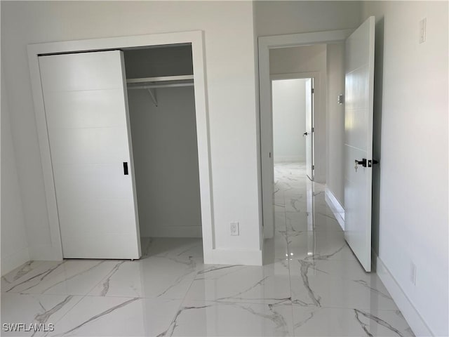 707 NE Juanita Place, Cape Coral, FL 33909 - unfurnished bedroom featuring light marble finish flooring and a closet