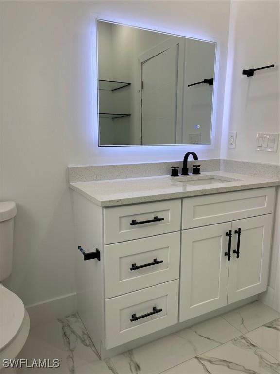 707 NE Juanita Place, Cape Coral, FL 33909 - bathroom featuring marble look tile flooring and vanity