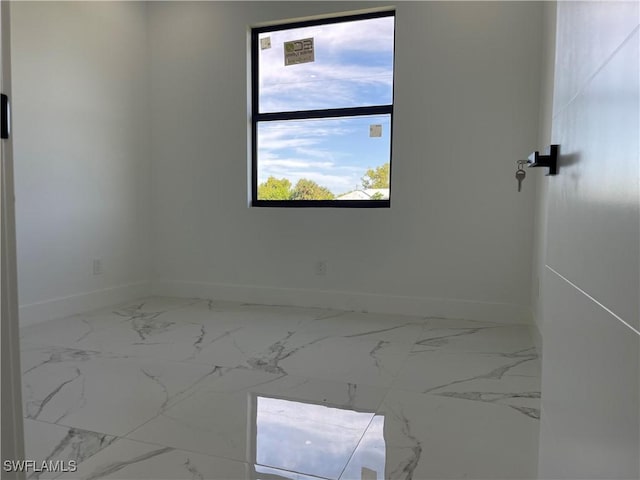 707 NE Juanita Place, Cape Coral, FL 33909 - unfurnished room featuring baseboards and marble look tiles