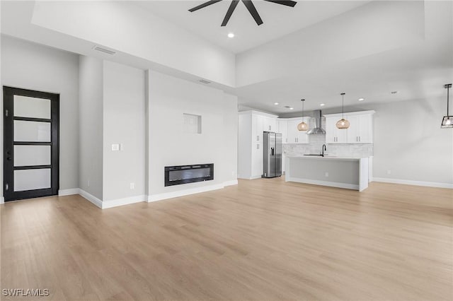 1299 Argosy Rd, Labelle, FL 33935 - unfurnished living room featuring ceiling fan, recessed lighting, light wood-type flooring, and a glass covered fireplace