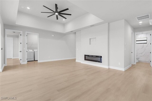 1299 Argosy Rd, Labelle, FL 33935 - unfurnished living room featuring separate washer and dryer, a raised ceiling, ceiling fan, light wood-type flooring, and recessed lighting