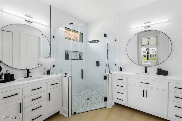 10490 Spruce Pine Ct, Fort Myers, FL 33913 - full bathroom with a shower stall, wood finished floors, and two vanities