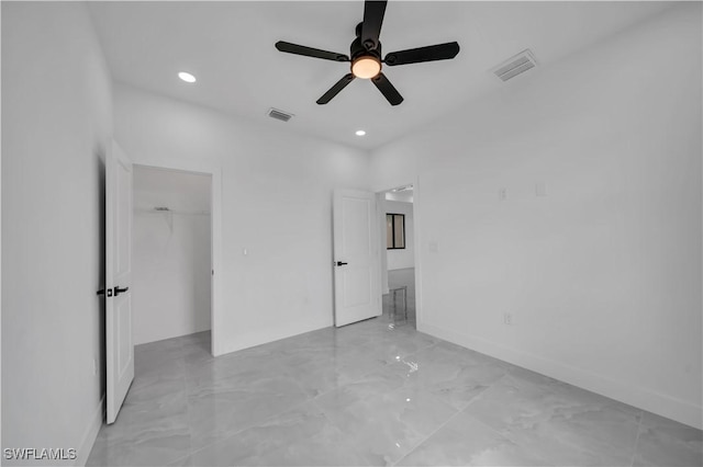 2018 Nelson Rd N, Cape Coral, FL 33993 - unfurnished bedroom featuring light marble finish floors, a walk in closet, recessed lighting, a ceiling fan, and a closet