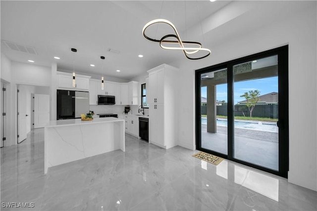 2018 Nelson Rd N, Cape Coral, FL 33993 - kitchen featuring refrigerator, white cabinetry, light countertops, black dishwasher, and decorative light fixtures
