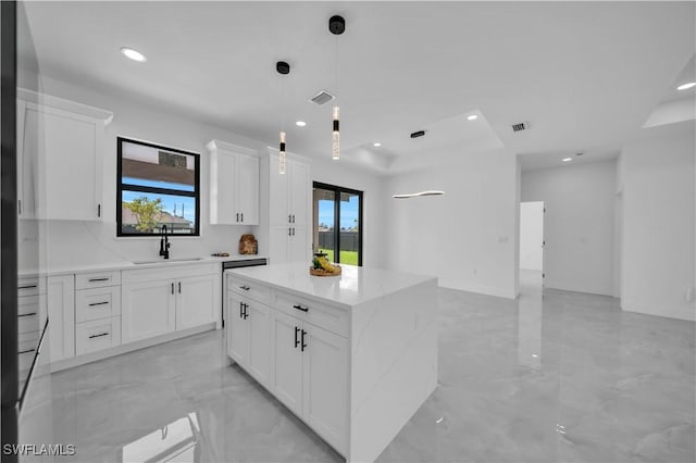 2018 Nelson Rd N, Cape Coral, FL 33993 - kitchen featuring a kitchen island, light marble finish flooring, light stone counters, white cabinets, and recessed lighting