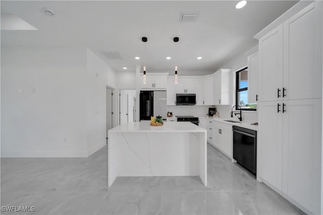 2018 Nelson Rd N, Cape Coral, FL 33993 - kitchen with black appliances, a kitchen island, white cabinets, recessed lighting, and hanging light fixtures