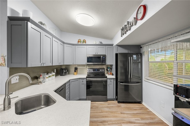 343 Golden Gate Blvd E, Naples, FL 34120 - kitchen with appliances with stainless steel finishes, gray cabinetry, lofted ceiling, decorative backsplash, and light wood-style floors