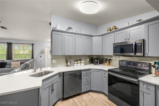 343 Golden Gate Blvd E, Naples, FL 34120 - kitchen featuring stainless steel appliances, gray cabinets, open floor plan, light countertops, and a peninsula