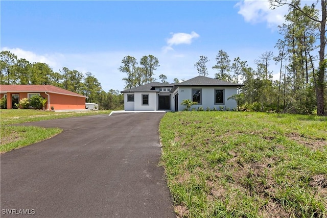 4371 47th Ave NE, Naples, FL 34120 - view of front of house with asphalt driveway, stucco siding, and a front lawn