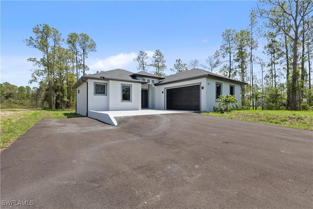 4371 47th Ave NE, Naples, FL 34120 - prairie-style home featuring an attached garage, stucco siding, and driveway