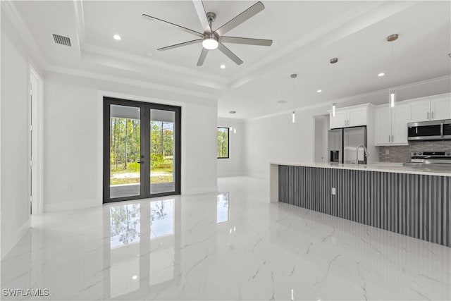 4371 47th Ave NE, Naples, FL 34120 - kitchen with stainless steel appliances, open floor plan, a raised ceiling, backsplash, and light countertops