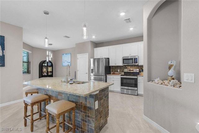 14659 Adina Ln, Fort Myers, FL 33905 - kitchen with stainless steel appliances, decorative backsplash, a breakfast bar, white cabinets, and recessed lighting