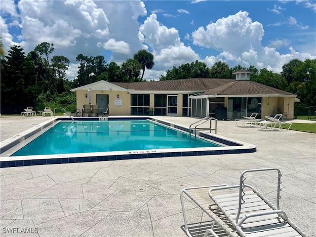 331 Joel Blvd Unit 109, Lehigh Acres, FL 33936 - community pool featuring a patio and view of wooded area