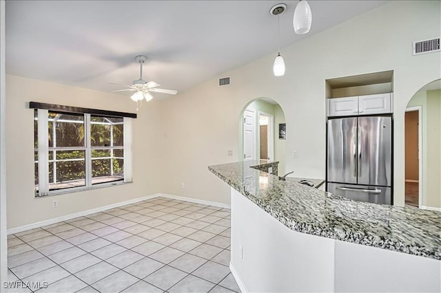 914 SW 9th Ct, Cape Coral, FL 33991 - kitchen featuring stainless steel fridge, a ceiling fan, arched walkways, vaulted ceiling, and stone countertops