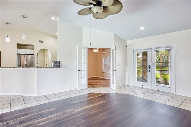914 SW 9th Ct, Cape Coral, FL 33991 - unfurnished living room with french doors, a ceiling fan, lofted ceiling, wood finished floors, and arched walkways