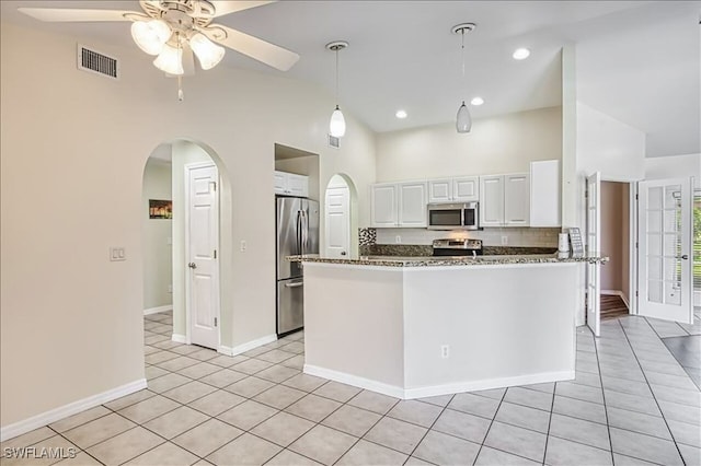 914 SW 9th Ct, Cape Coral, FL 33991 - kitchen featuring stainless steel appliances, arched walkways, ceiling fan, white cabinetry, and light tile patterned flooring