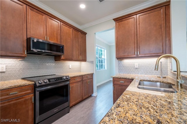6533 Monterey Pt Unit 204, Naples, FL 34105 - kitchen featuring stainless steel appliances, ornamental molding, light stone countertops, wood finished floors, and tasteful backsplash