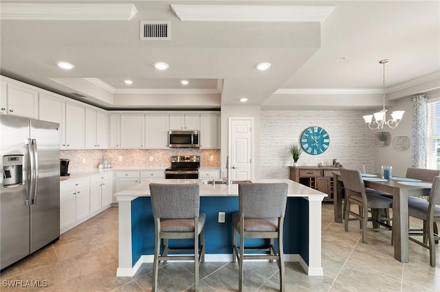 10720 Palazzo Way Unit 405, Fort Myers, FL 33913 - kitchen featuring stainless steel appliances, ornamental molding, tasteful backsplash, a chandelier, and white cabinets